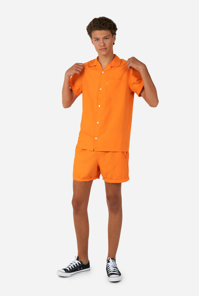 Teen wearing orange summer set, consisting of shirt and short.