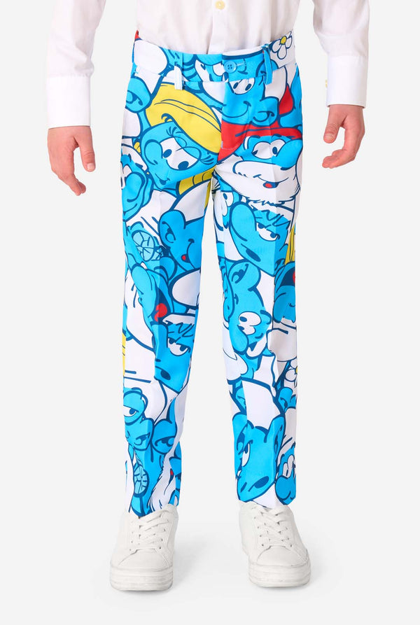 Young boy wearing a colorful Smurfs-themed kids suit featuring vibrant blue cartoon character prints, including jacket, pants, and matching tie, smiling against a plain white background. Pants close up.