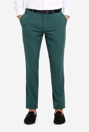 Image with light grey background and man wearing dark green men’s suit and white shirt. Suits consists of blazer and pants. Pants close up.