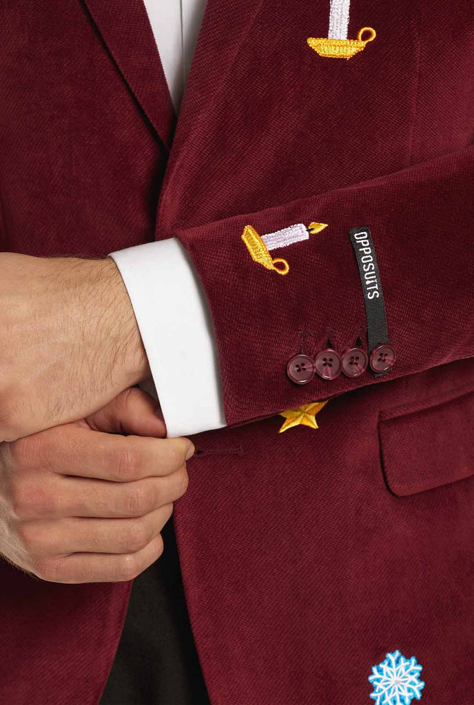 Man wearing burgundy red velvet Christmas blazer with Christmas icons