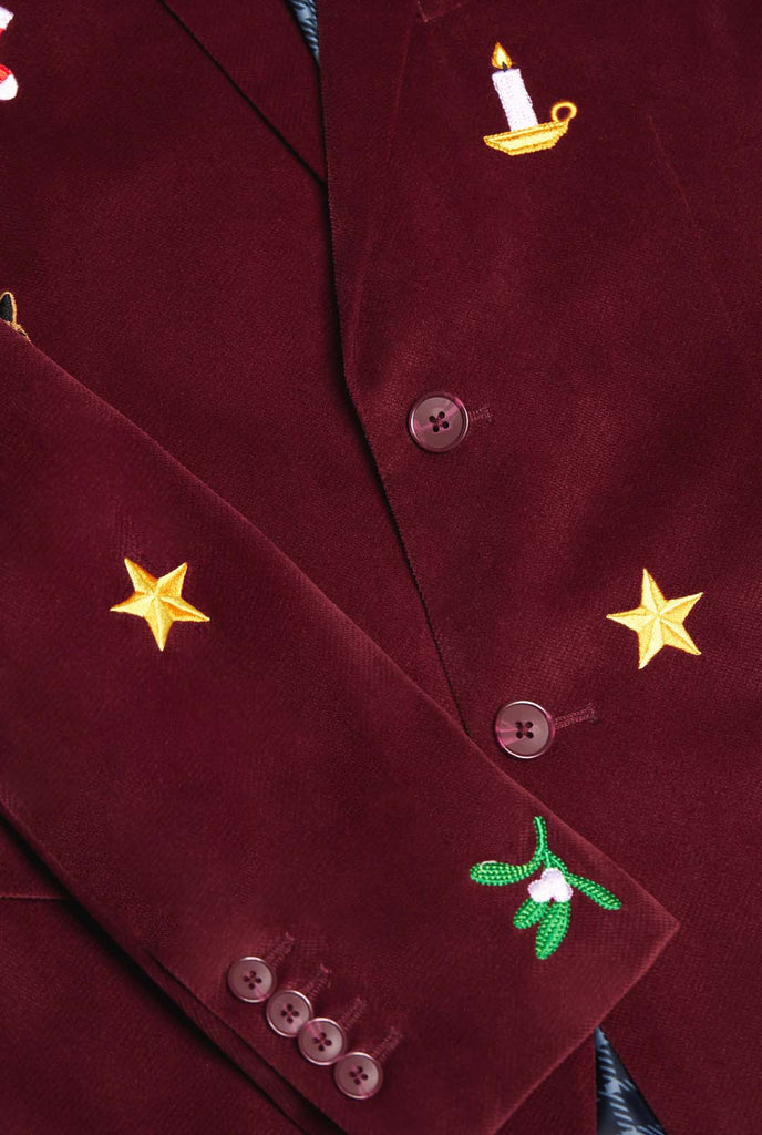 Man wearing burgundy red velvet Christmas blazer with Christmas icons, close up