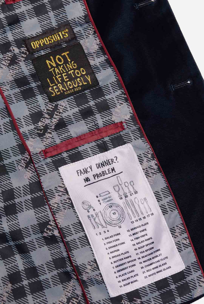 Man wearing navy blue Christmas blazer with Christmas embroidery, close up inside