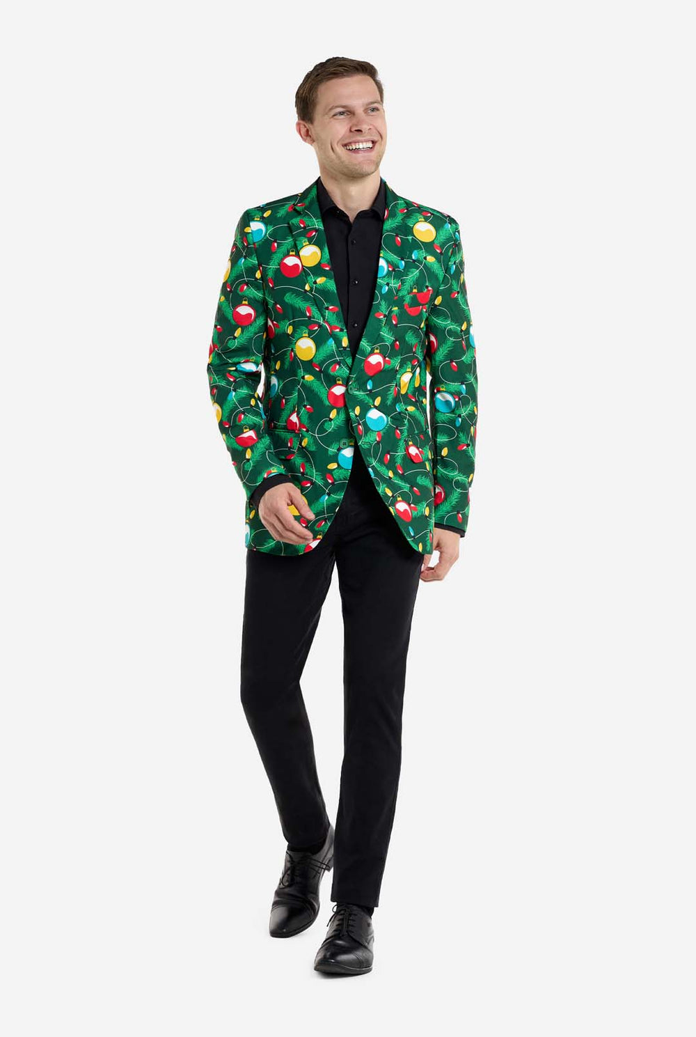 Man wearing green Christmas blazer for men with decorated Christmas tree print. Man also wearing a black pants and black men's shirt.