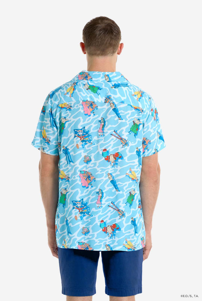 Man wearing blue Hawaiian shirt with One Piece character print. View from the back.