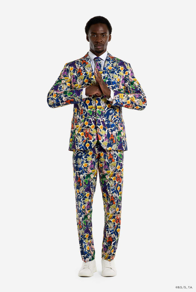 Man wearing all over print men's suit with Dragon Ball Z print which shows the Dragon Ball characters. Suit consists of Blazer, pant and tie. Full body image.