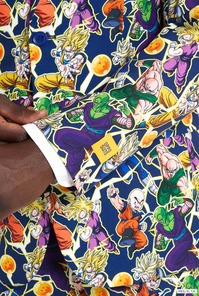 Man wearing all over print men's suit with Dragon Ball Z print which shows the Dragon Ball characters. Suit consists of Blazer, pant and tie. Sleeve close up.