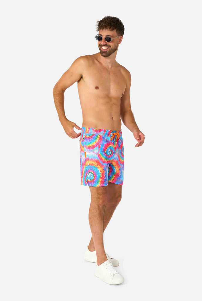 Men's rainbow tie-dye swim shorts with a bold, colorful spiral pattern. A fun and trendy choice for beach days and pool parties.