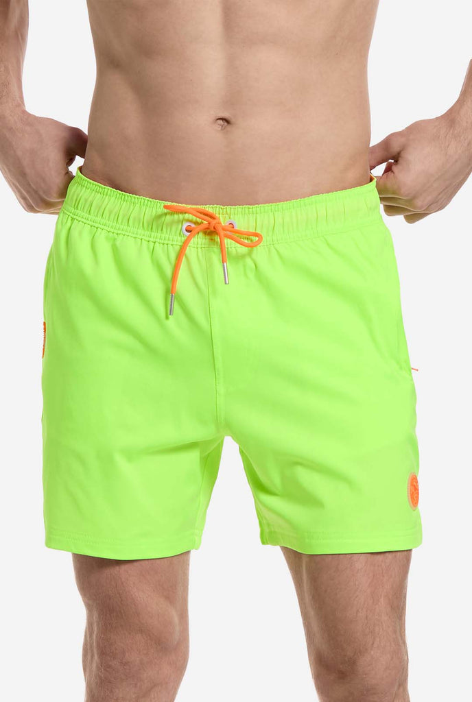 Man wearing Neon lime green swim trunks for men, close up