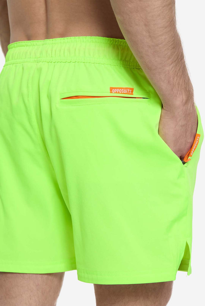 Man wearing Neon lime green swim trunks for men, close up
