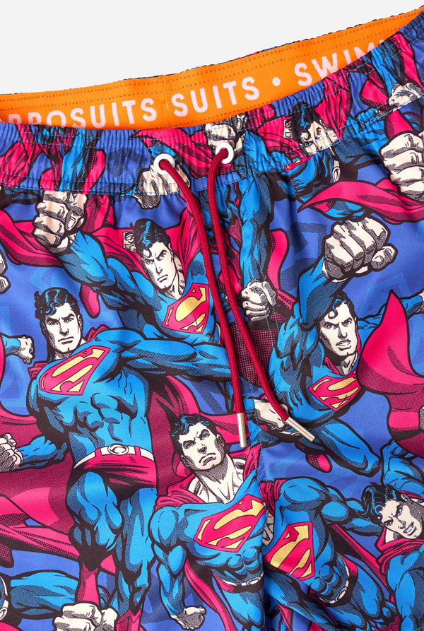 Men's Superman-themed swim shorts featuring a bold comic book design with multiple action poses of the Man of Steel. Perfect for superhero fans looking to make a splash. Close-up strings.