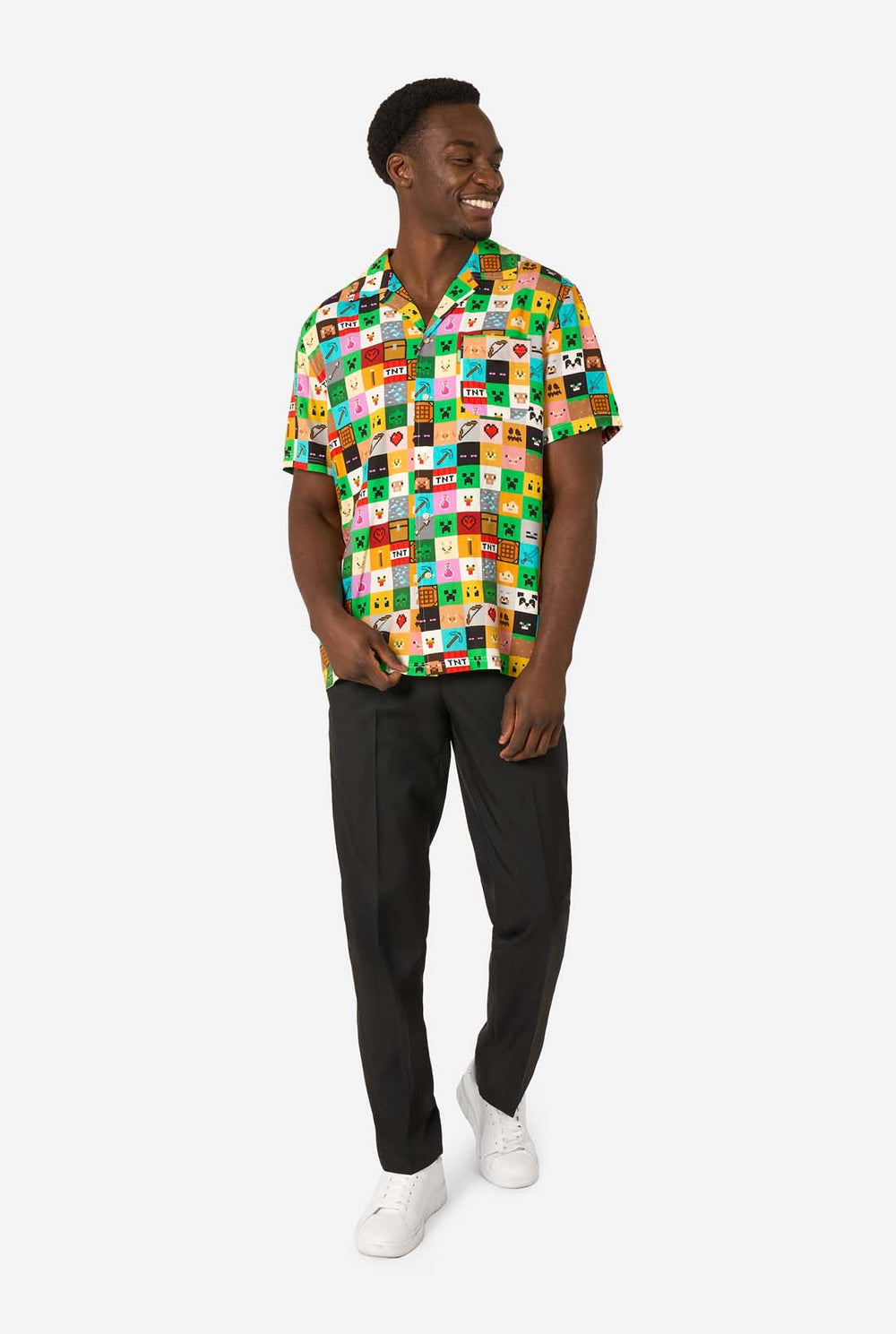 Man wearing a colorful Minecraft Hawaiian shirt featuring pixelated blocks, characters, and items from the game, paired with black pants, standing against a plain white background.