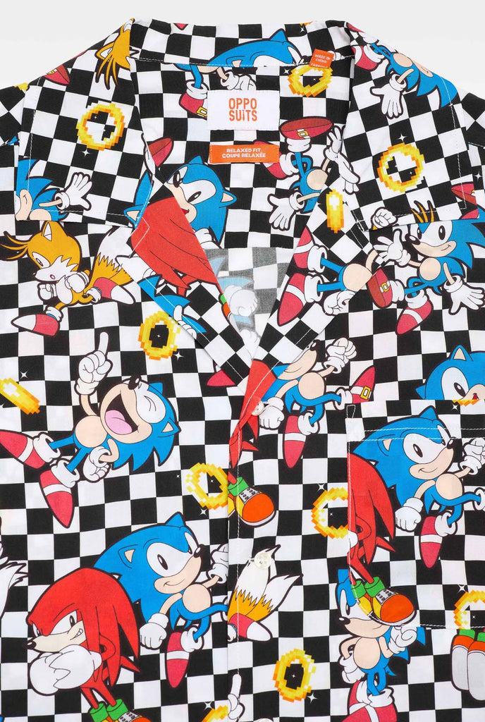 Close up of a black and white checkered Hawaiian shirt with characters from the Sonic the Hedgehog franchise and golden rings on it. 