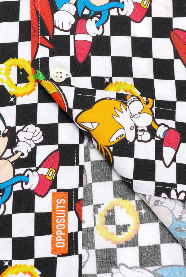Close up of a black and white checkered Hawaiian shirt with characters from the Sonic the Hedgehog franchise and golden rings on it. Showing the bottom part of the shirt.