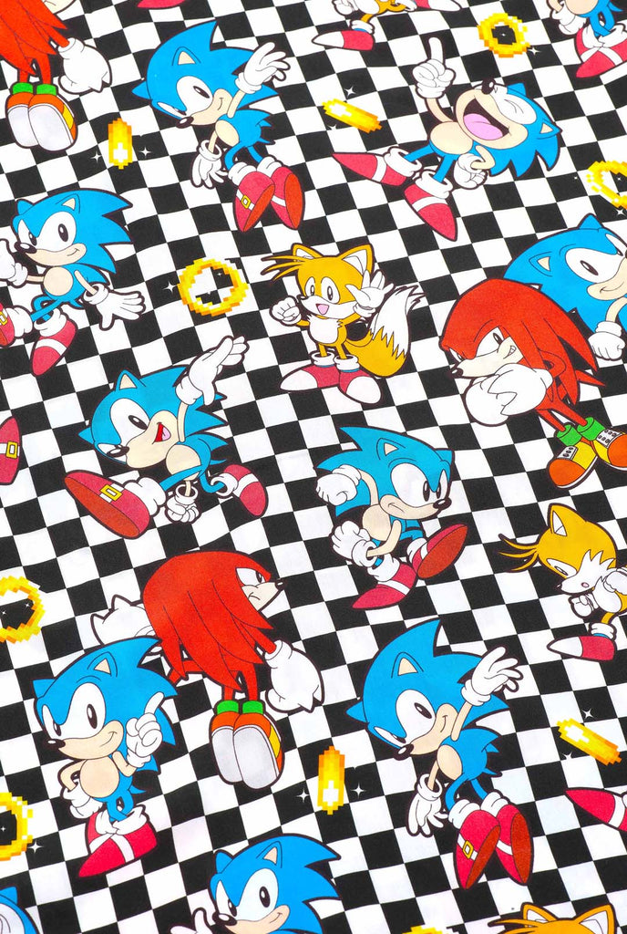 Close up of a black and white checkered Hawaiian shirt with characters from the Sonic the Hedgehog franchise and golden rings on it. Showing the print with different characters like: Sonic, Knuckles, Tails and golden rings.