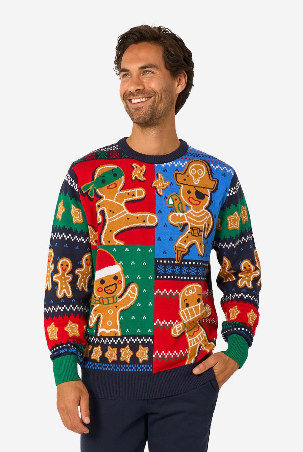 Man wearing a colorful sweater with gingerbread man patterns on a white background