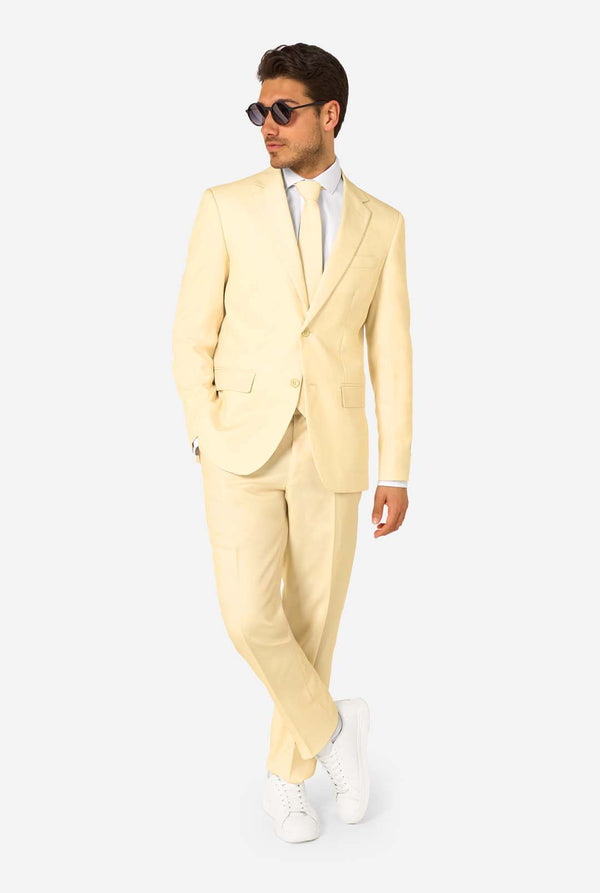 Elegant men's suit in a soft pastel yellow shade, perfect for weddings, summer events, and formal occasions. This stylish tailored suit features a slim fit design, notch lapels, and a matching tie for a sophisticated look. Ideal for modern gentlemen looking to make a statement with a light-colored pastel suit. Also wearing sunglasses.