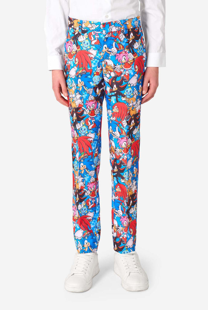 Teen boy wearing a vibrant Sonic teen suit featuring colorful prints of Sonic the Hedgehog characters including Sonic, Knuckles, Tails, and Amy, paired with a matching tie and white shirt. Pants close up.