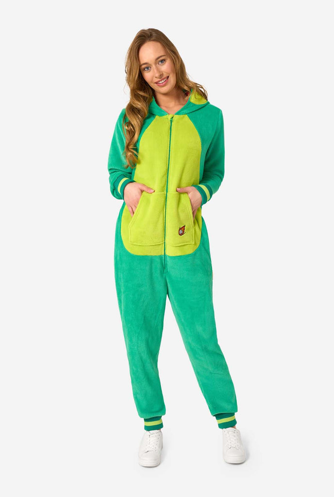 A woman is wearing a green dinosaur adult onesie featuring playful hood details and cozy, soft material, perfect for lounging or costume events.