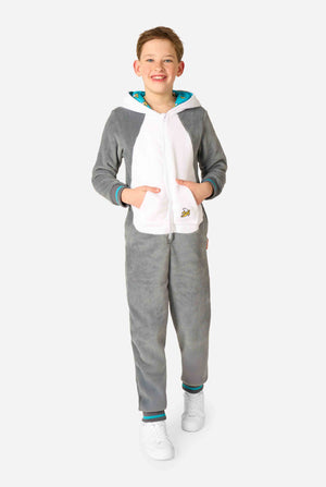 Child wearing a cozy unisex kids onesie designed as a lemur, featuring grey and white plush fabric, a hood with a cartoon lemur face and ears, and a playful banana print on the pocket. Full body image.