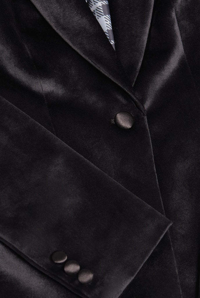 Woman wearing golden velvet dinner jacket blazer