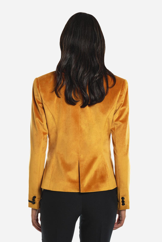 Woman wearing golden velvet dinner jacket blazer