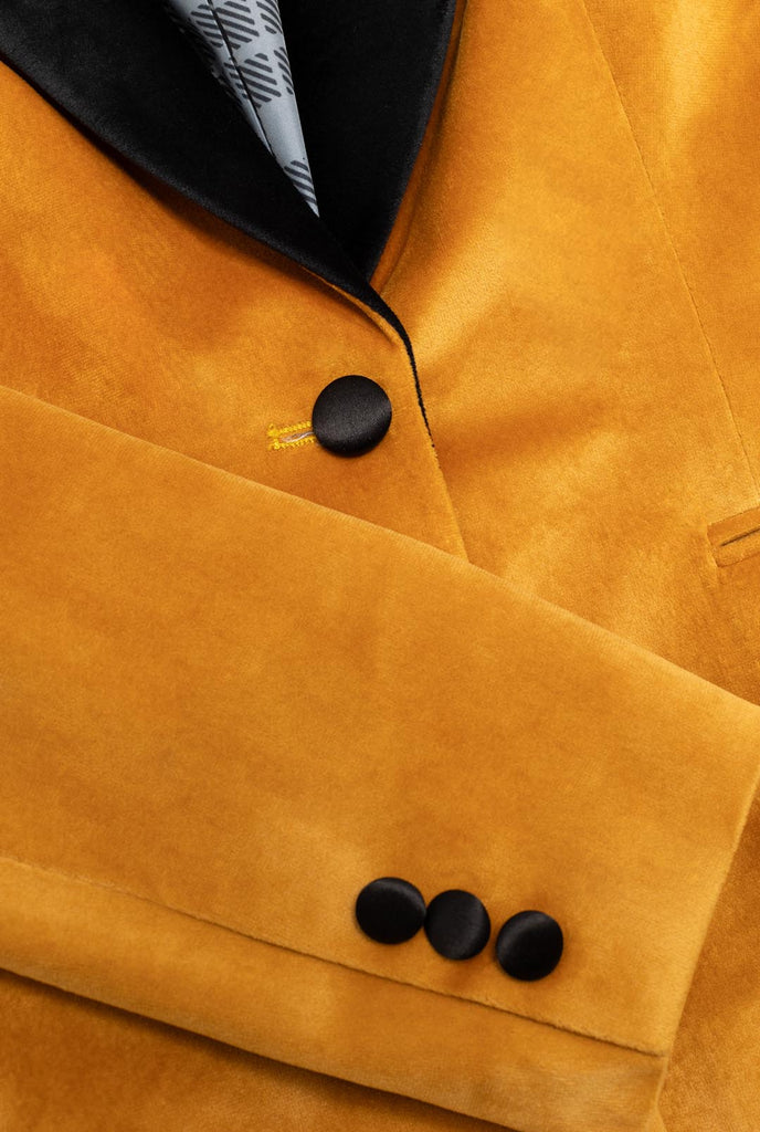 Woman wearing golden velvet dinner jacket blazer