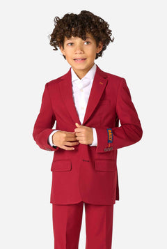 Kid wearing a stylish burgundy red suit with a white dress shirt, looking confidently. Perfect formal outfit for boys' special occasions, weddings, and parties.