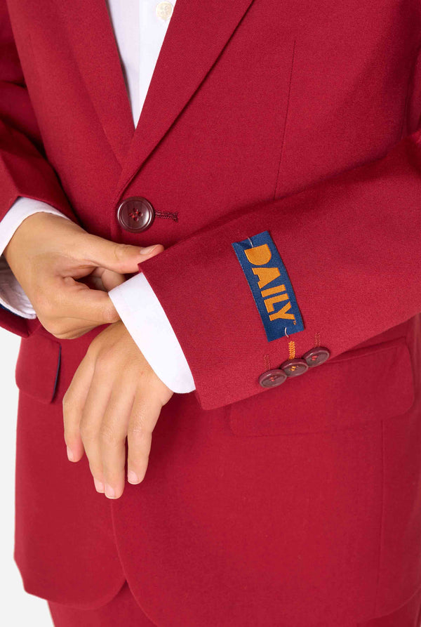 Kid wearing a stylish burgundy red suit with a white dress shirt, looking confidently. Perfect formal outfit for boys' special occasions, weddings, and parties. Sleeves close up.