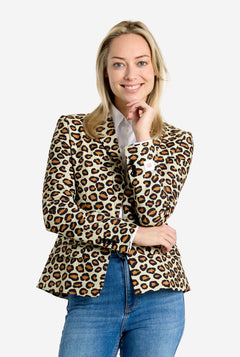 Woman wearing a leopard print blazer and blue jeans on a white background