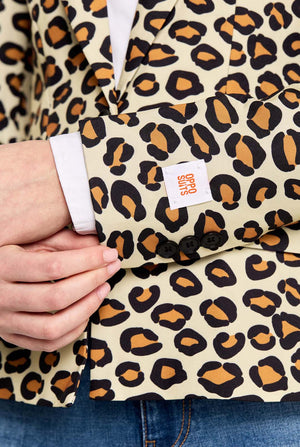 Leopard print fabric with a visible brand label held by a person wearing jeans.