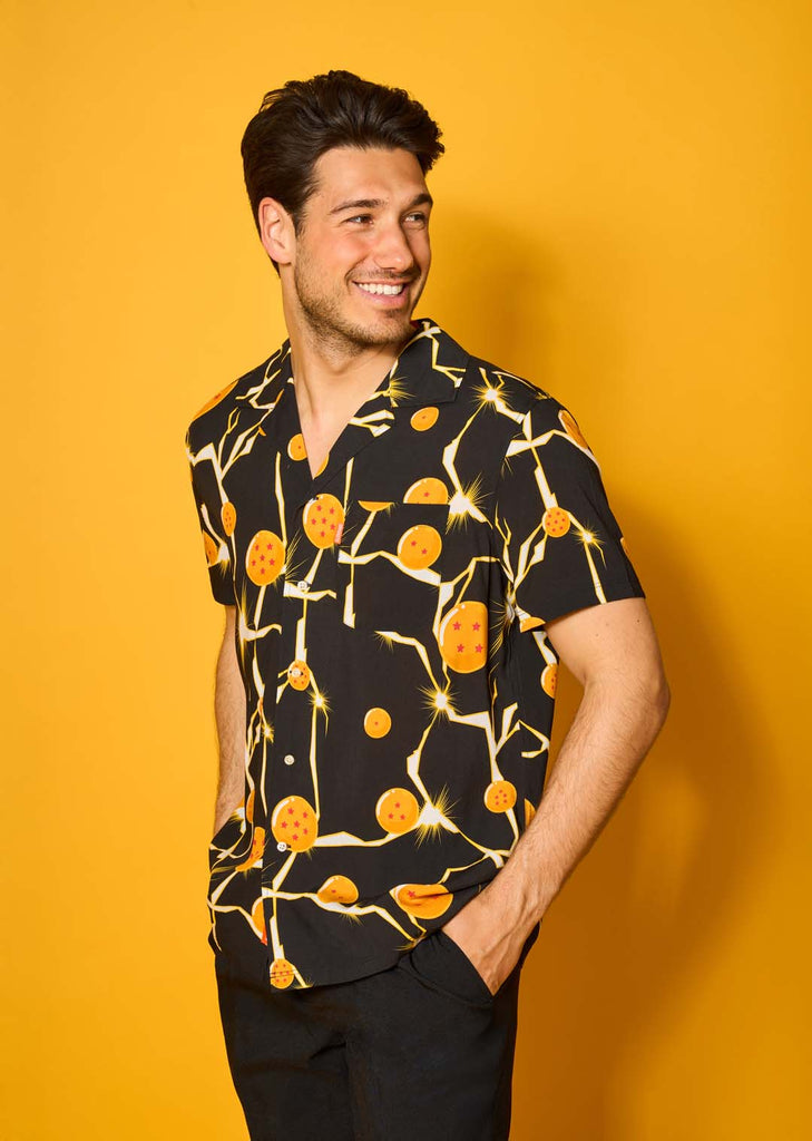 Image with yellow background and a man in a black Dragon Ball Hawaiian.