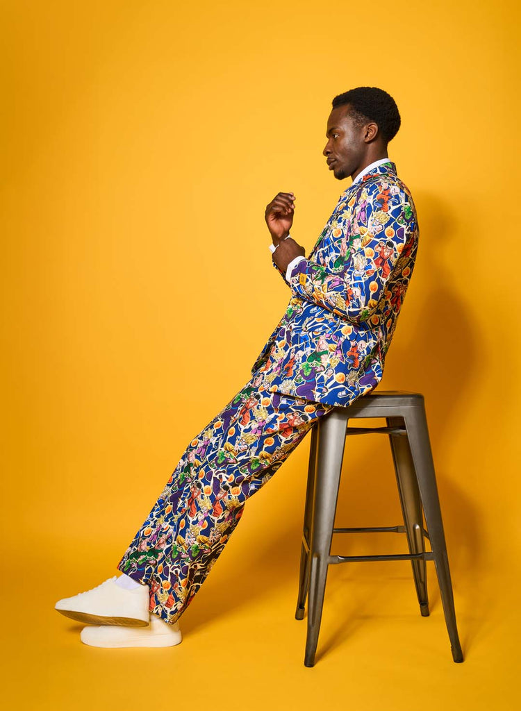 Image with yellow background and a man in a blue Dragon Ball suit on a stool.