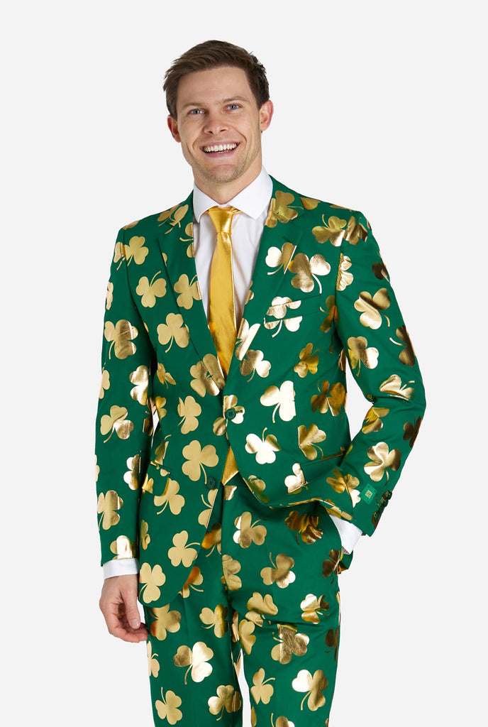 Man wearing green St Patrick's Day suit with golden clovers.